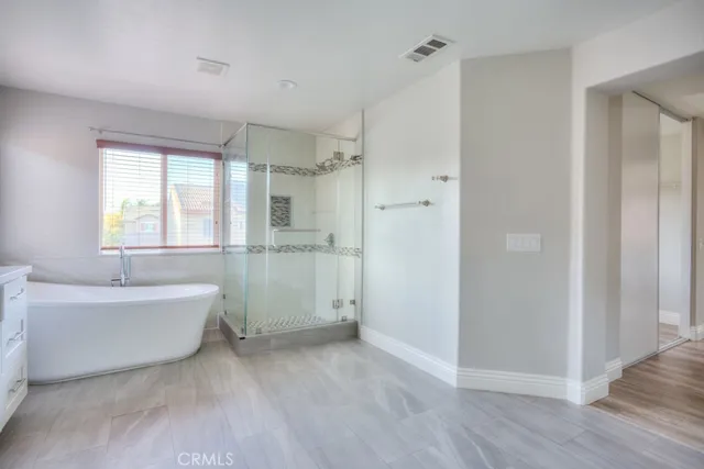 a bathroom with a tub a window and a shower