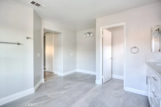 an empty room with wooden floor and a bathroom