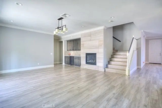 a view of a livingroom with wooden floor and staircase
