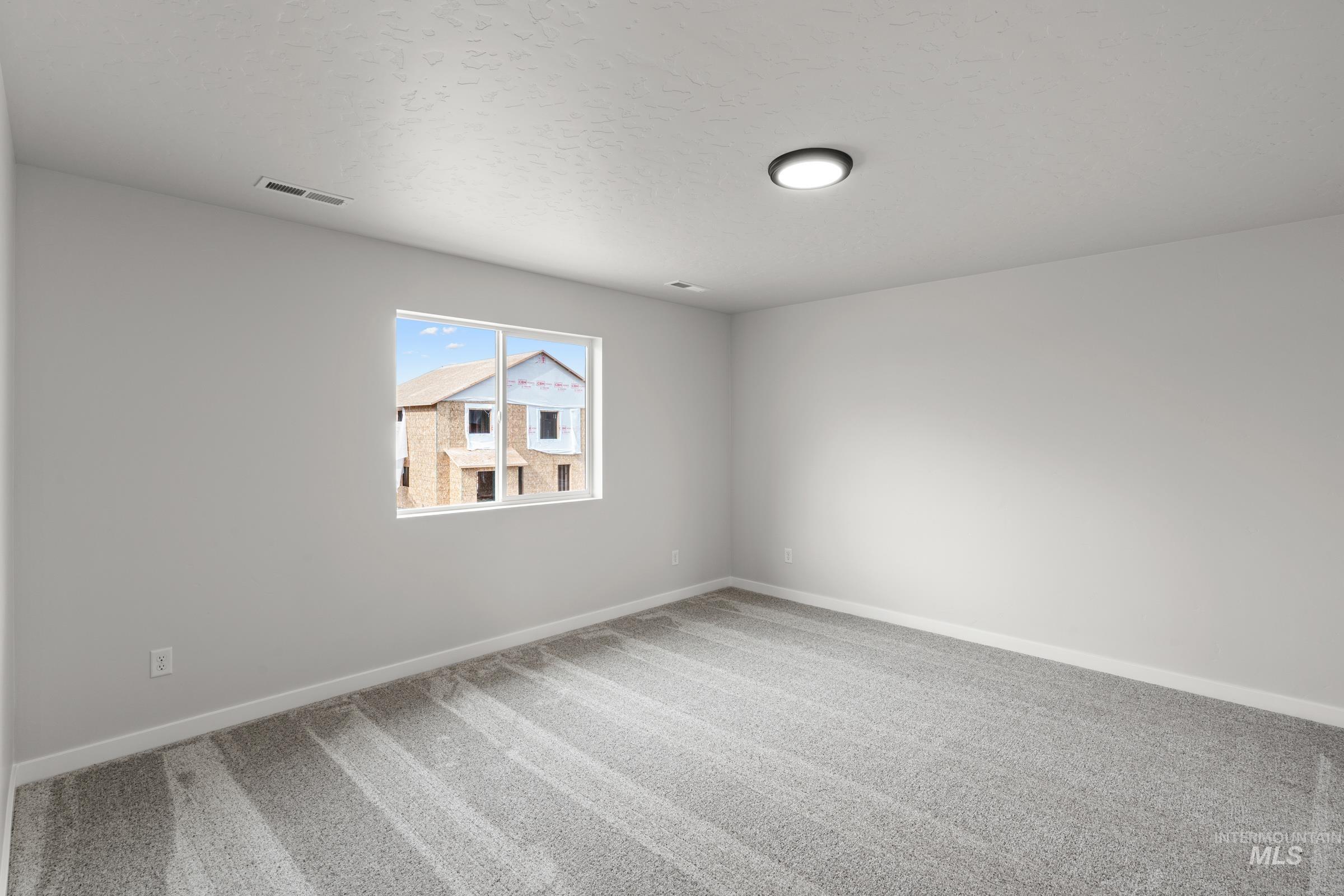 14056 Shiny Spruce Street Caldwell, ID 83607 - Photo 18 of 25 Room featuring light gray walls, gray patterned carpeting, and white trim