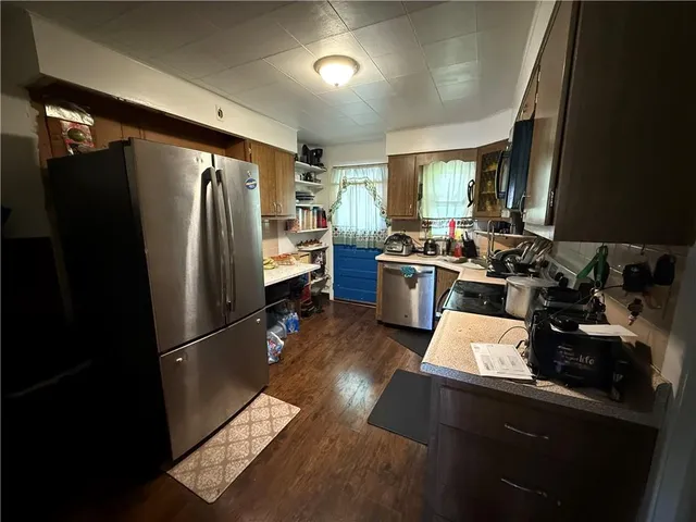 a kitchen with stainless steel appliances a refrigerator a sink a stove and cabinets