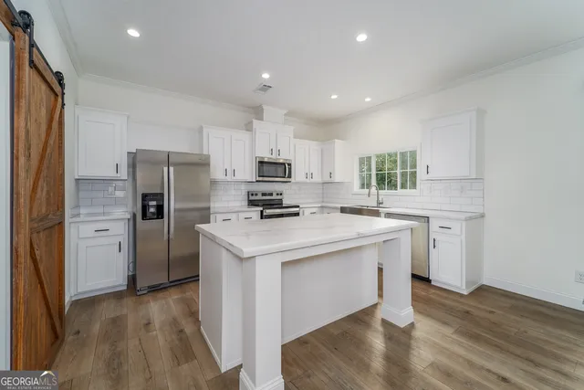 a kitchen with a refrigerator a sink and a microwave