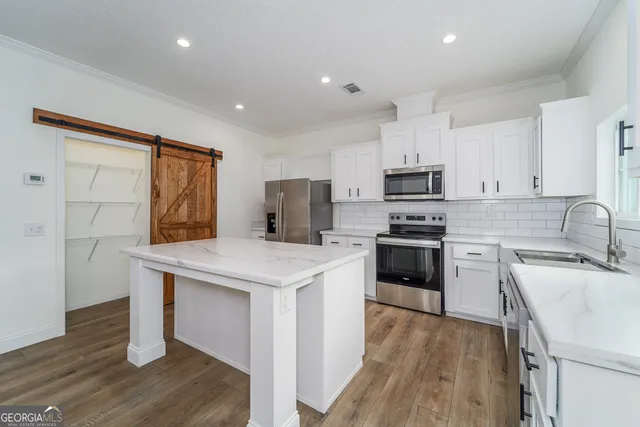 a kitchen with granite countertop a sink stove and refrigerator