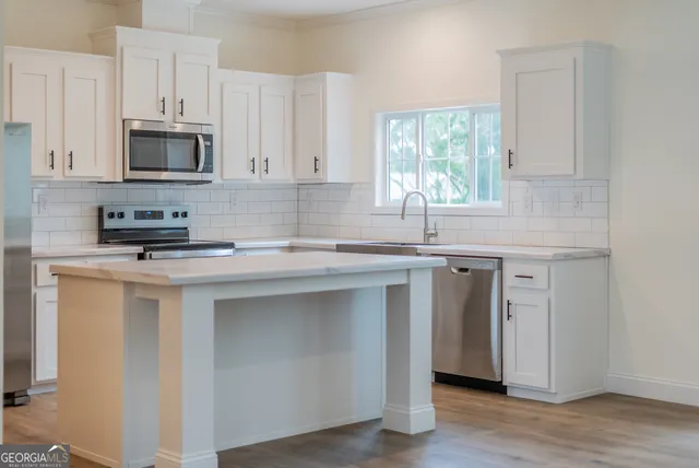 a kitchen with stainless steel appliances a sink stove and microwave
