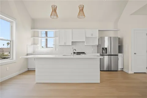a kitchen with kitchen island a sink stainless steel appliances and window