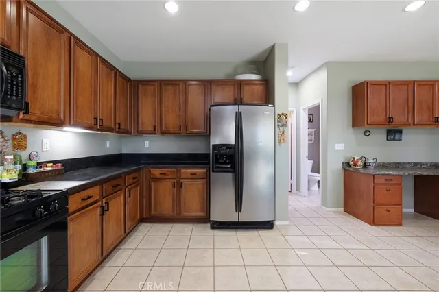a kitchen with stainless steel appliances granite countertop a refrigerator sink and stove