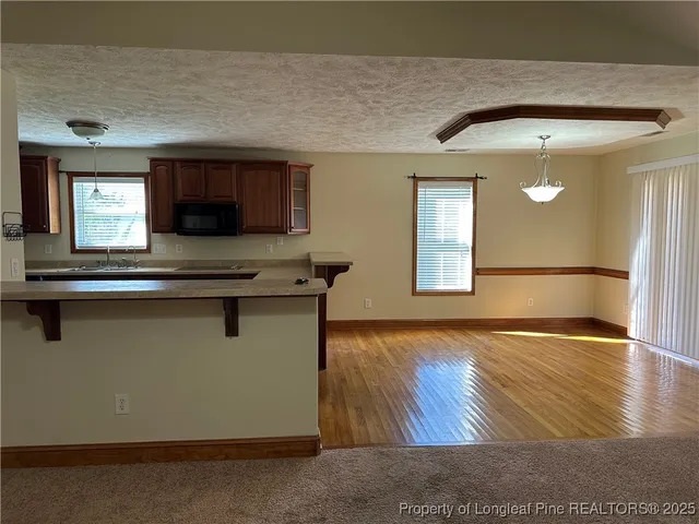 a view of kitchen with wooden floor and a window