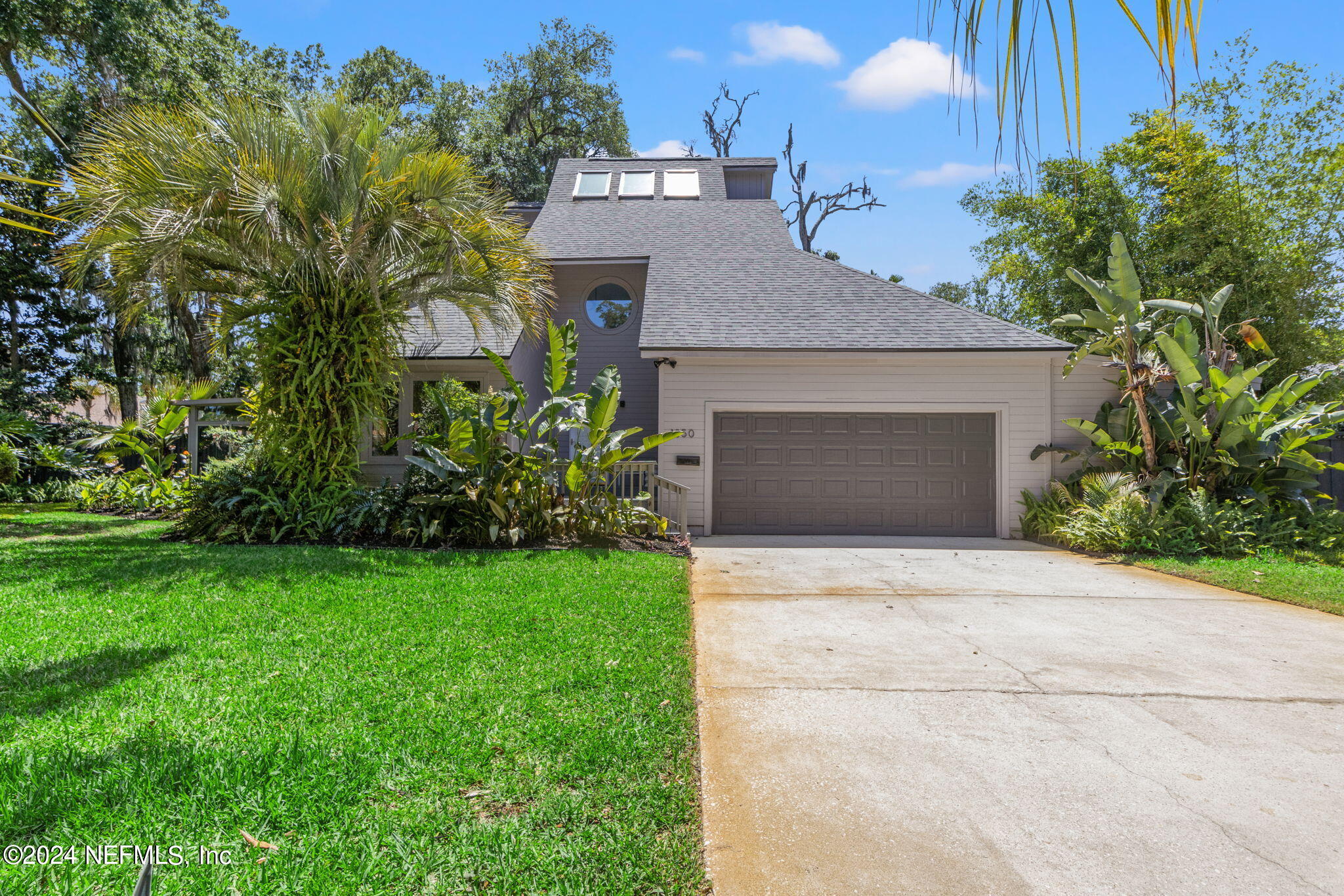 1350 Pinewood Road Jacksonville Beach, FL 32250 - Photo 3 of 55 a front view of a house with a garden and garage