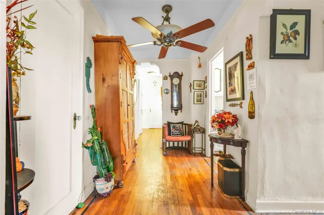 a view of a hallway with wooden floor and a potted plant