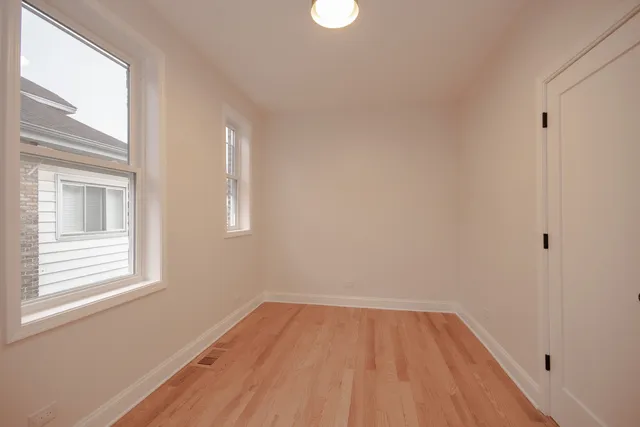 a view of a room that has wooden floor and windows