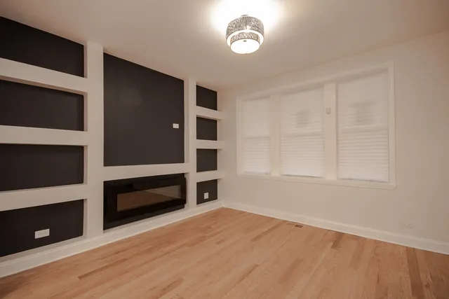 a view of an empty room with a fireplace and a window