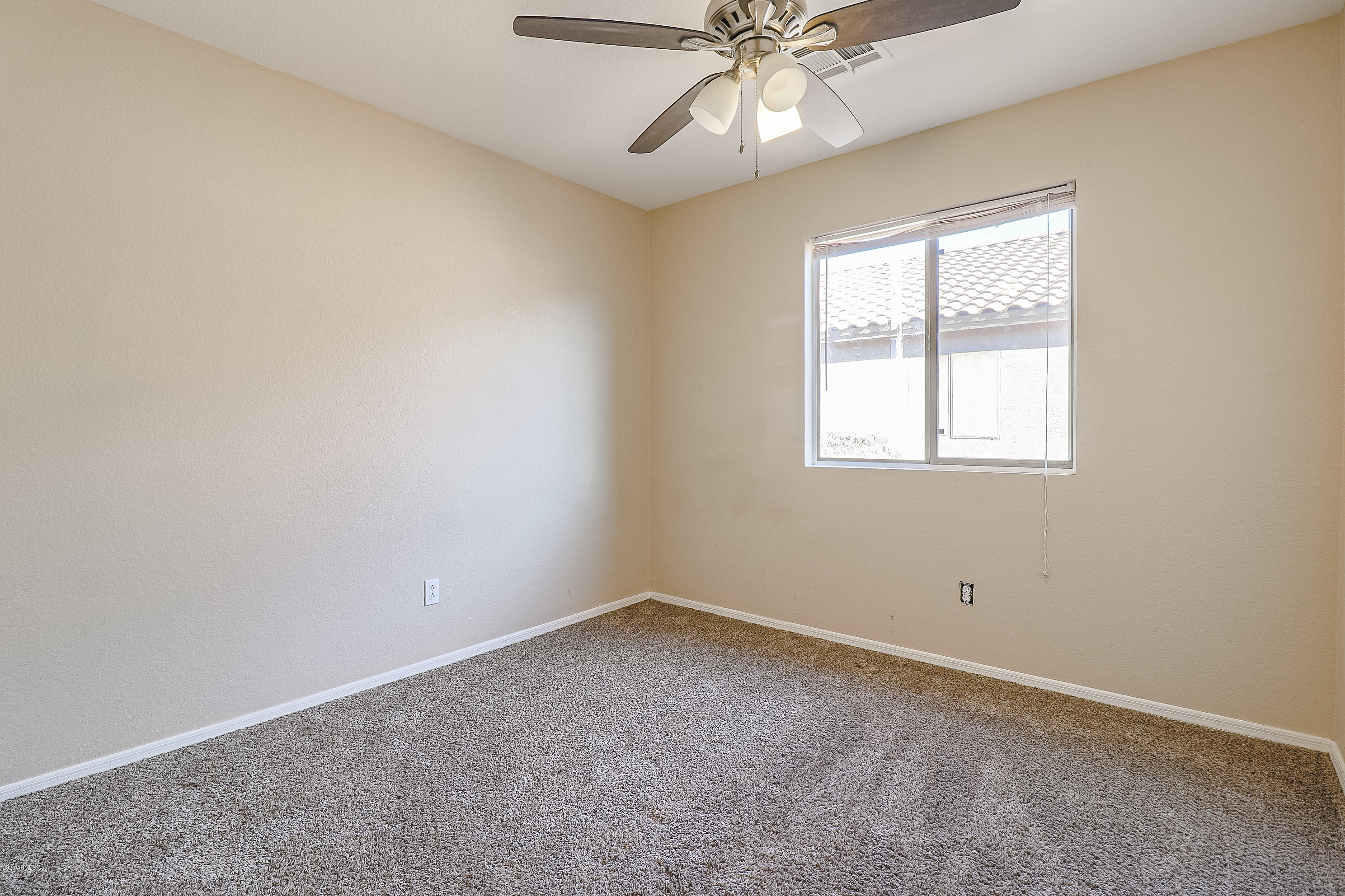 15038 West Redfield Road Surprise, AZ 85379 - Photo 12 of 21 an empty room with windows and fan chandelier