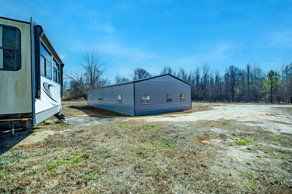 900 Asaville School Road Anderson, SC 29621 - Photo 4 of 29 This expansive lot features a durable metal structure, offering versatile space for various needs.
