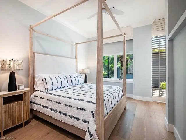 a large bed sitting in a bedroom next to a window