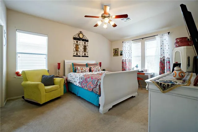 a bedroom with a bed a couch and a chandelier