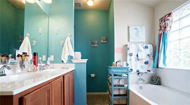 a bathroom with a bathtub sink and mirror