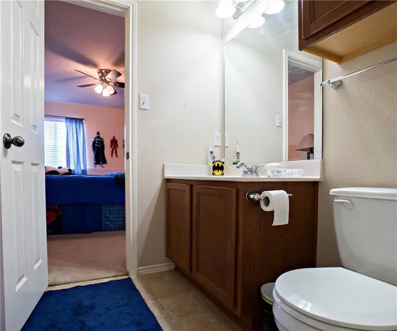 a bathroom with a sink a toilet a mirror and shower