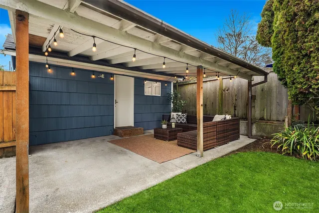 a view of a chair and table in backyard of the house