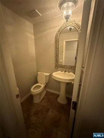 a bathroom with a toilet a sink and mirror