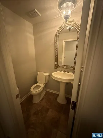 a bathroom with a toilet a sink and mirror
