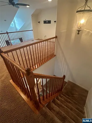a view of staircase with railing and a rug