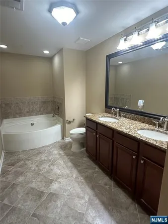 a bathroom with a sink a toilet a mirror and shower