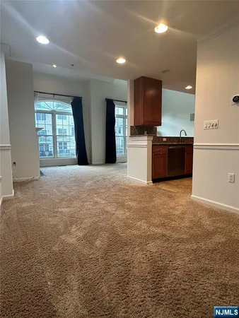 a living room with kitchen island granite countertop furniture and a flat screen tv