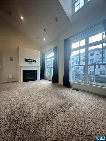 a view of an empty room with a fireplace and a window