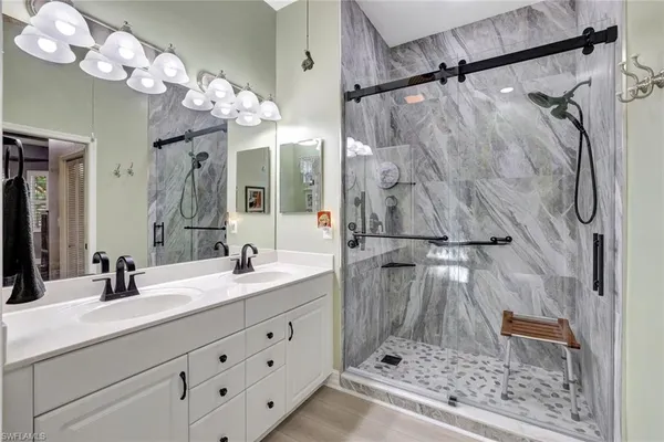 a bathroom with a sink vanity mirror and shower