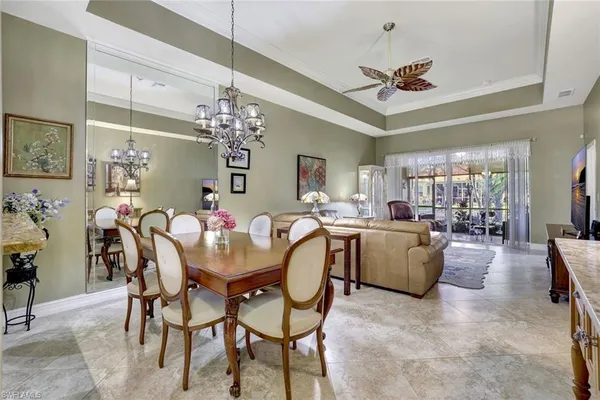 a dining room with furniture a chandelier and window