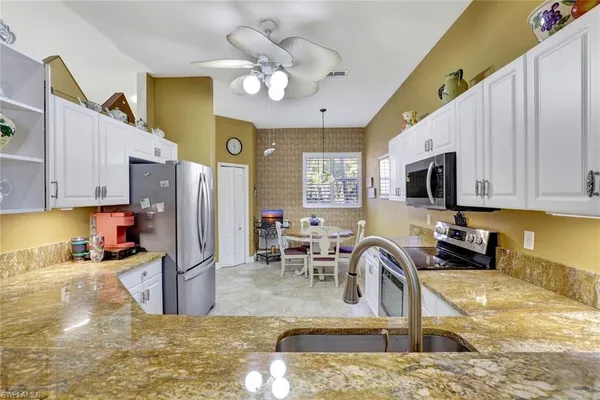 a kitchen with stainless steel appliances granite countertop a sink a stove top oven a granite counter space and cabinets