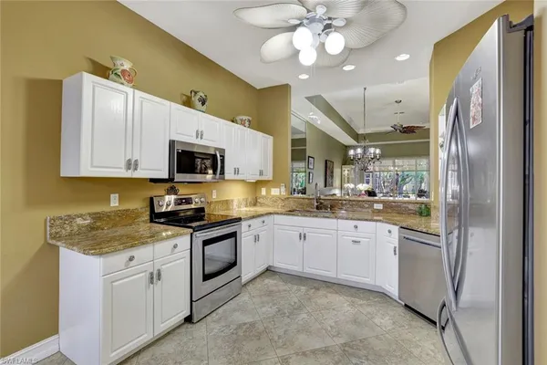 a kitchen with granite countertop stainless steel appliances a stove microwave and cabinets