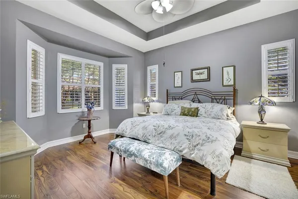 a bedroom with a bed and a table chair with the wooden floor