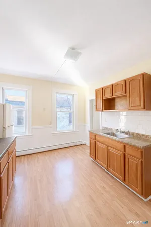 a open kitchen with stainless steel appliances granite countertop a sink and dishwasher a stove with wooden floors