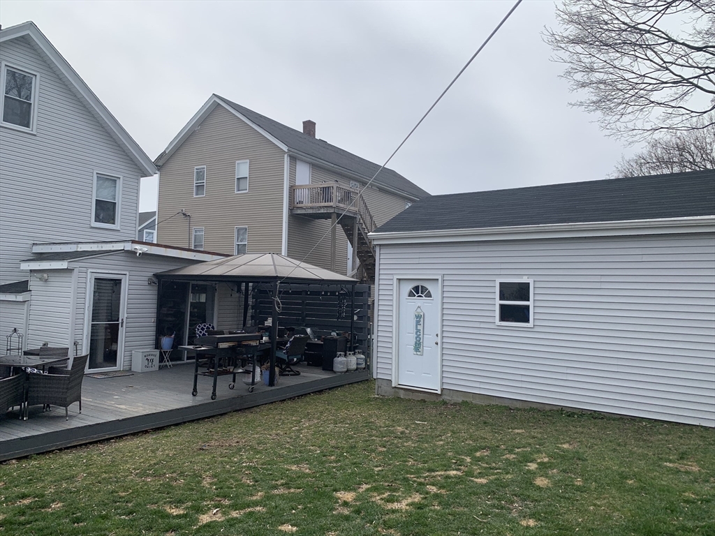 149 Smith Street Fall River, MA 02721 - Photo 34 of 38 a view of a patio with table and chairs potted plants and a large tree