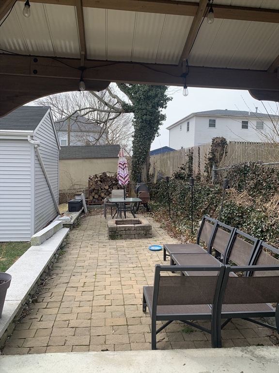 149 Smith Street Fall River, MA 02721 - Photo 38 of 38 a view of a patio with table and chairs under an umbrella with a small yard