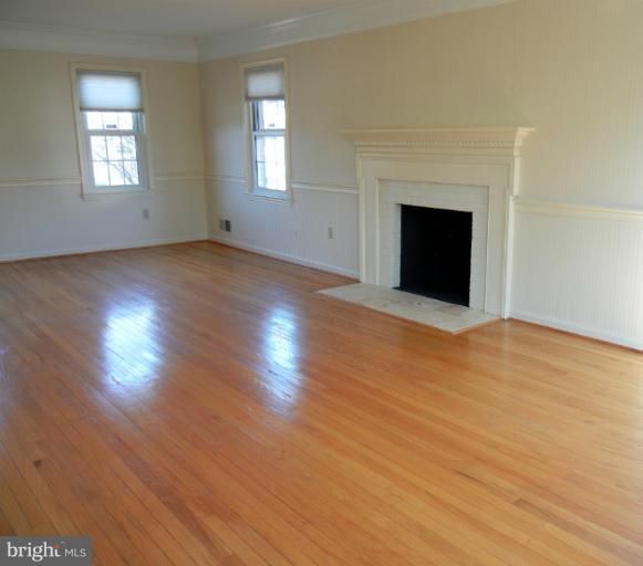 8413 Riverside Road Alexandria, VA 22308 - Photo 20 of 28 an empty room with wooden floor fireplace and windows