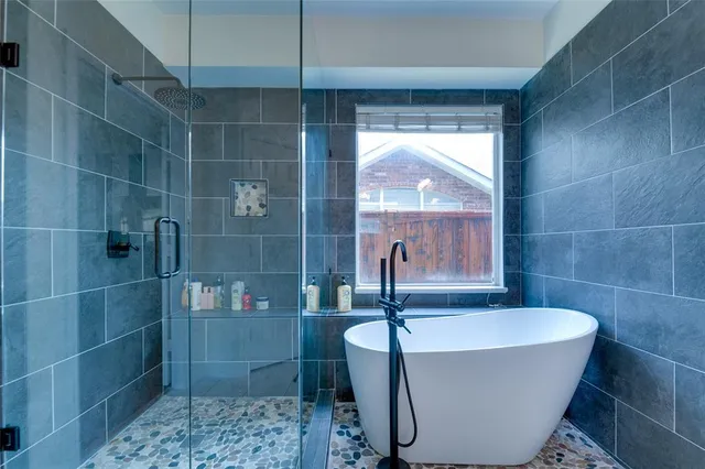 a white bath tub sitting in a bathroom next to a window