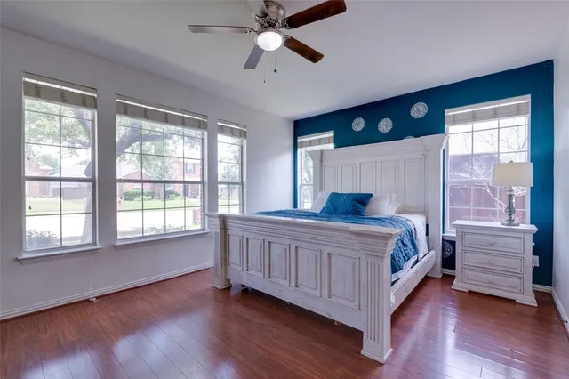 a bedroom with a bed and large windows
