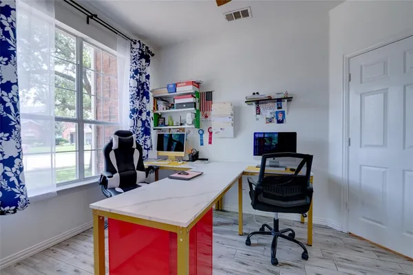 a view of a workspace with furniture and a window