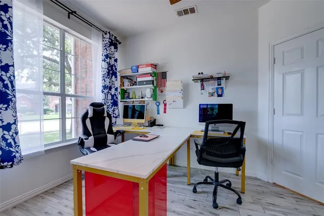 a view of a workspace with furniture and a window