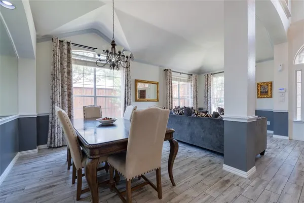 a dining room with furniture a chandelier and wooden floor