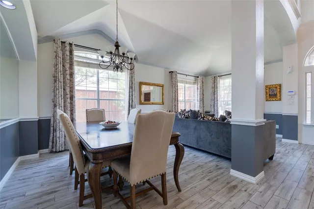 a dining room with furniture a chandelier and wooden floor
