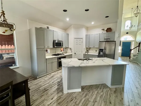 a kitchen with kitchen island a sink stainless steel appliances and cabinets