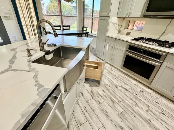 a kitchen with a stove a sink and a microwave