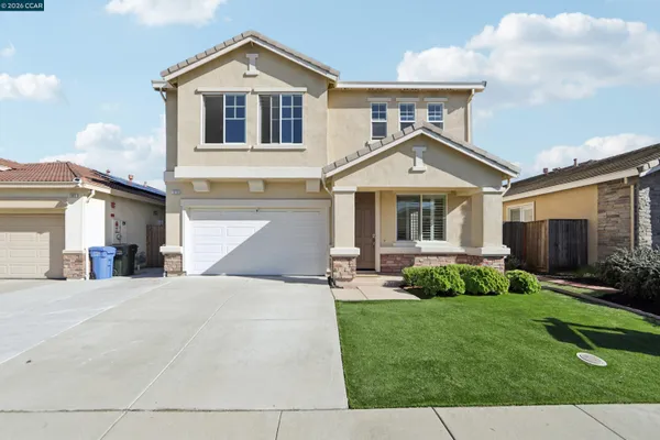 a front view of a house with a yard and garage