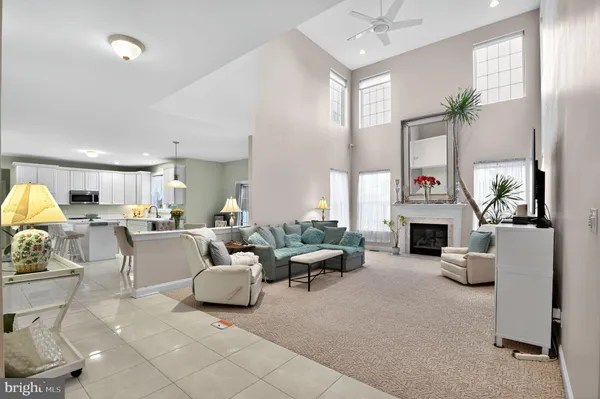 a living room with furniture a fireplace and a chandelier