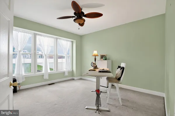 a view of a workspace with furniture and a window