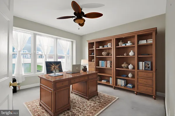 a view of a workspace with furniture and a window