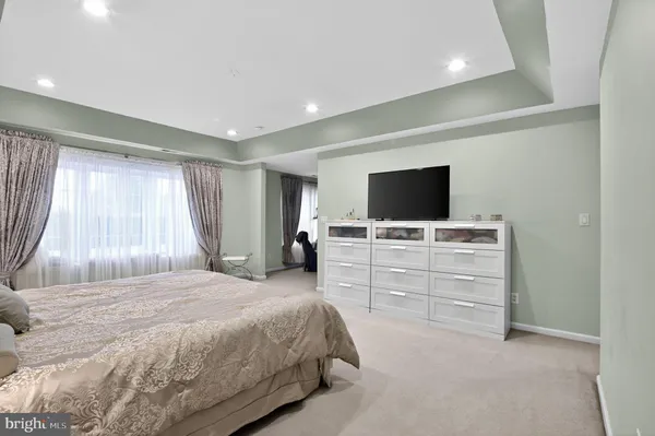 a spacious bedroom with a bed and a flat screen tv